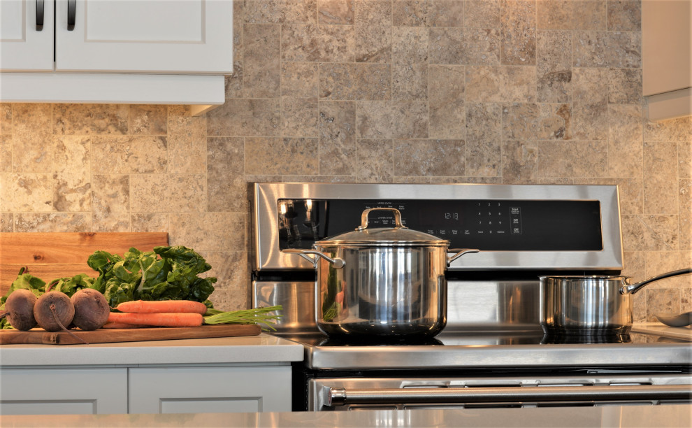 Large transitional l-shaped medium tone wood floor and brown floor open concept kitchen photo in Toronto with an undermount sink, shaker cabinets, white cabinets, quartz countertops, multicolored backsplash, marble backsplash, stainless steel appliances, an island and white countertops