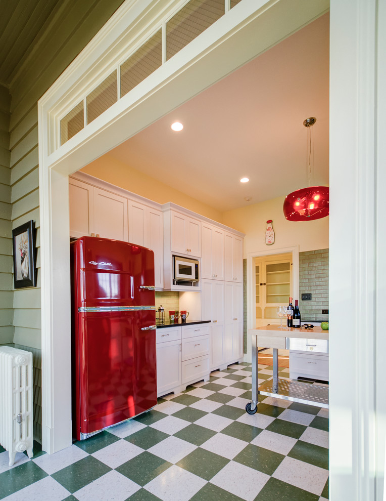 Photo of a small country u-shaped eat-in kitchen in DC Metro with flat-panel cabinets, white cabinets, quartz benchtops, coloured appliances, linoleum floors and with island.