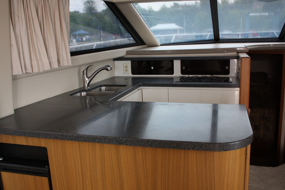 Small transitional u-shaped eat-in kitchen photo with a double-bowl sink, flat-panel cabinets, white cabinets, quartz countertops, a peninsula and white appliances