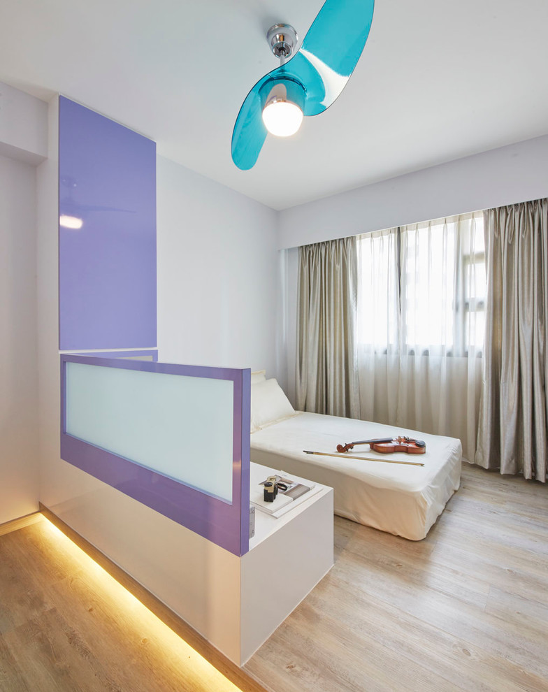This is an example of a mid-sized modern guest bedroom in Singapore with white walls and plywood floors.