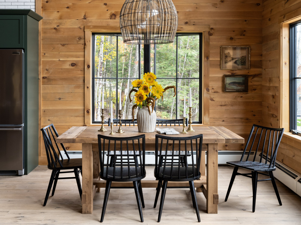 This is an example of a rustic dining room in Portland Maine with medium hardwood flooring and wood walls.