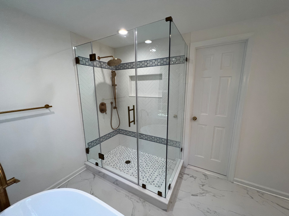 Photo of a medium sized contemporary bathroom in New York with a freestanding bath, a corner shower, a one-piece toilet, white tiles, ceramic tiles, white walls, porcelain flooring, an integrated sink, a hinged door and a wall niche.