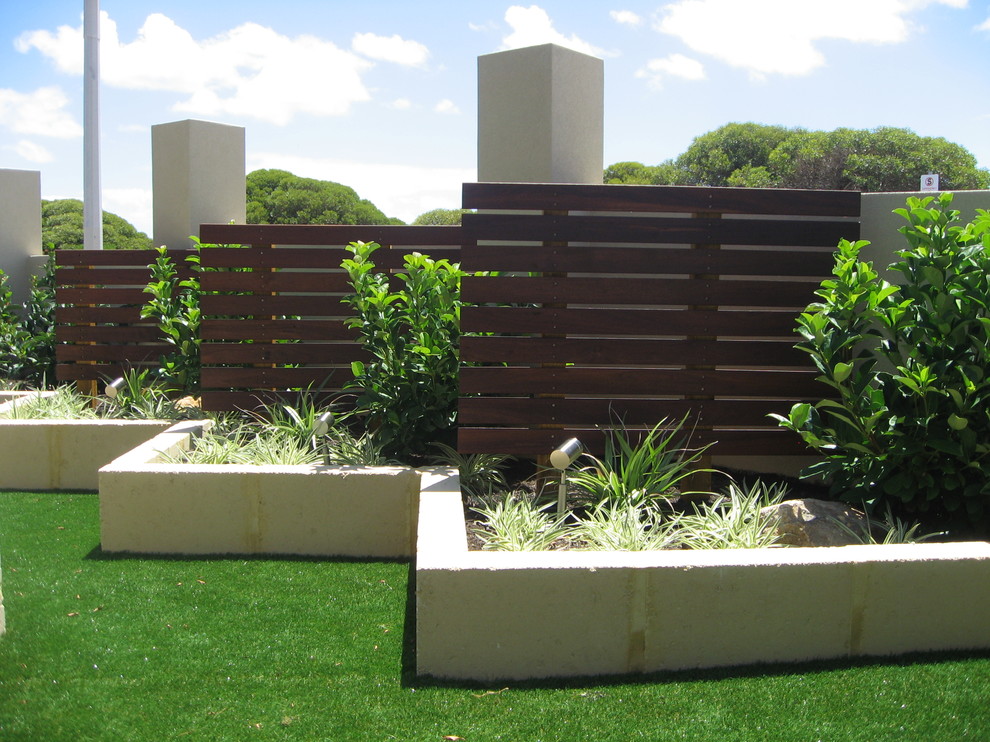 Inspiration for a mid-sized contemporary backyard full sun formal garden for summer in Perth with a retaining wall and decking.