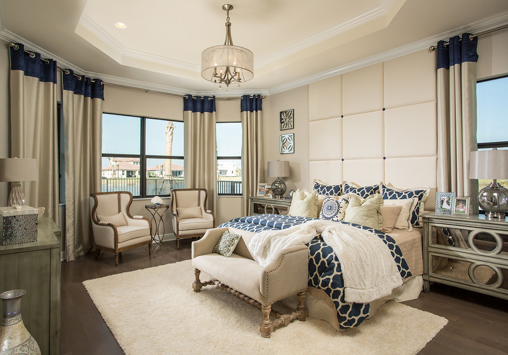 Large beach style master bedroom in Miami with beige walls, dark hardwood floors and brown floor.
