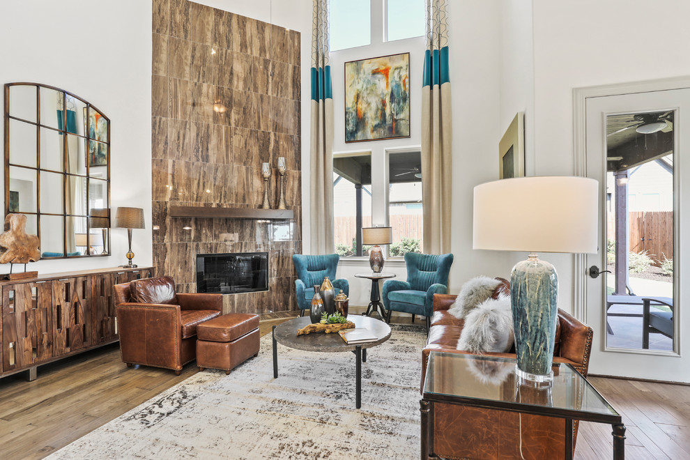 Photo of a large contemporary open concept living room in Dallas with beige walls, medium hardwood floors, a corner fireplace, a tile fireplace surround and brown floor.
