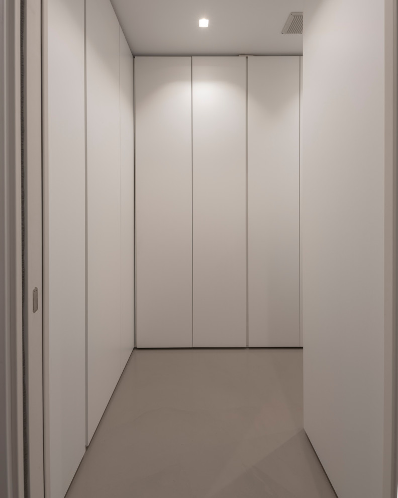 Immagine di una lavanderia multiuso minimalista di medie dimensioni con ante lisce, ante bianche, pareti bianche, lavatrice e asciugatrice a colonna, pavimento grigio e soffitto ribassato