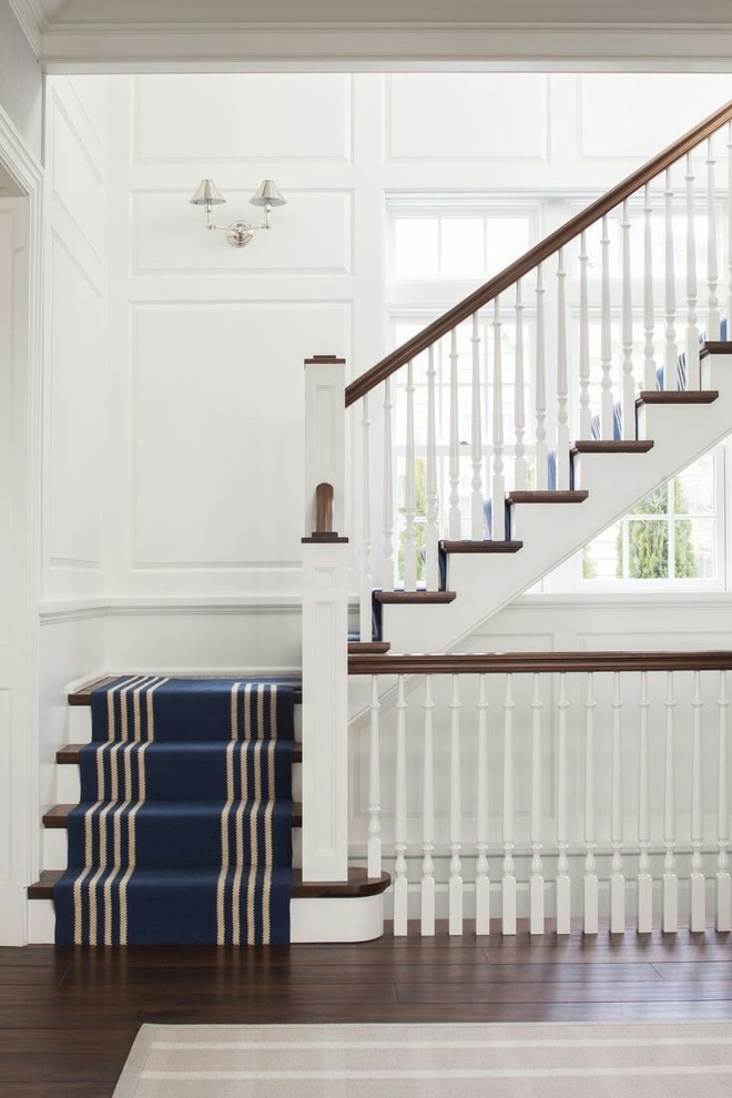 Large transitional wood l-shaped staircase in Other with painted wood risers and wood railing.