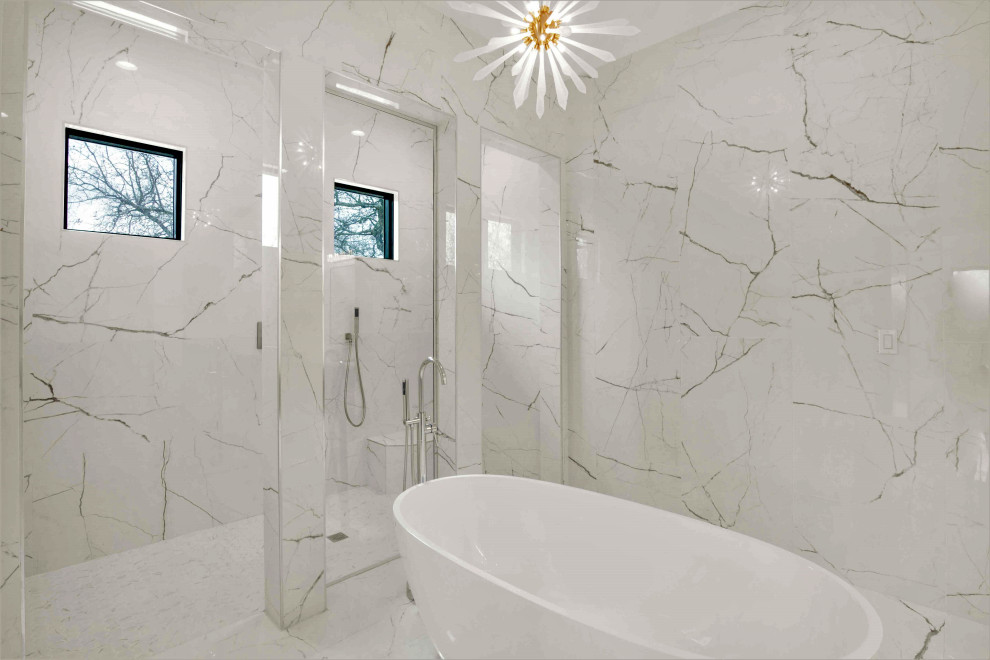 Пример оригинального дизайна: большая главная ванная комната в стиле модернизм с плоскими фасадами, серыми фасадами, отдельно стоящей ванной, двойным душем, унитазом-моноблоком, белой плиткой, керамогранитной плиткой, белыми стенами, полом из керамогранита, настольной раковиной, столешницей из искусственного кварца, белым полом, открытым душем, белой столешницей, сиденьем для душа, тумбой под две раковины и подвесной тумбой