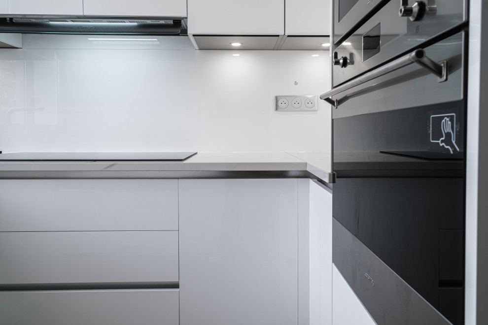 Inspiration for a medium sized modern u-shaped enclosed kitchen in Paris with an integrated sink, white cabinets and white worktops.