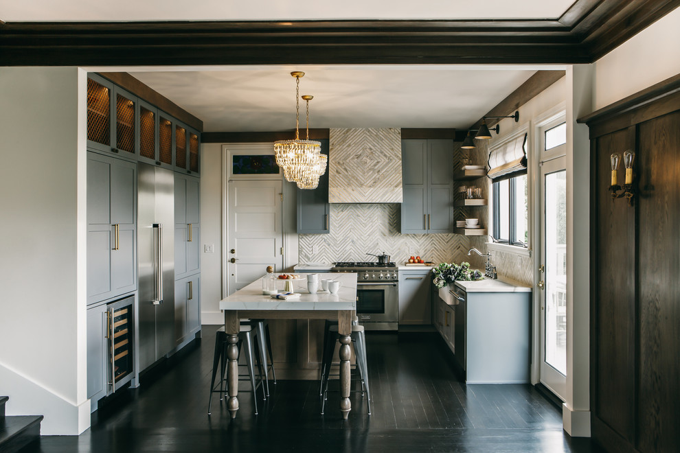 Inspiration for a mid-sized transitional u-shaped eat-in kitchen in San Francisco with a farmhouse sink, shaker cabinets, grey cabinets, quartz benchtops, white splashback, marble splashback, stainless steel appliances, dark hardwood floors, with island and black floor.