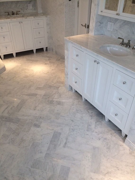 This is an example of a transitional bathroom in New York with white tile, marble floors and marble benchtops.