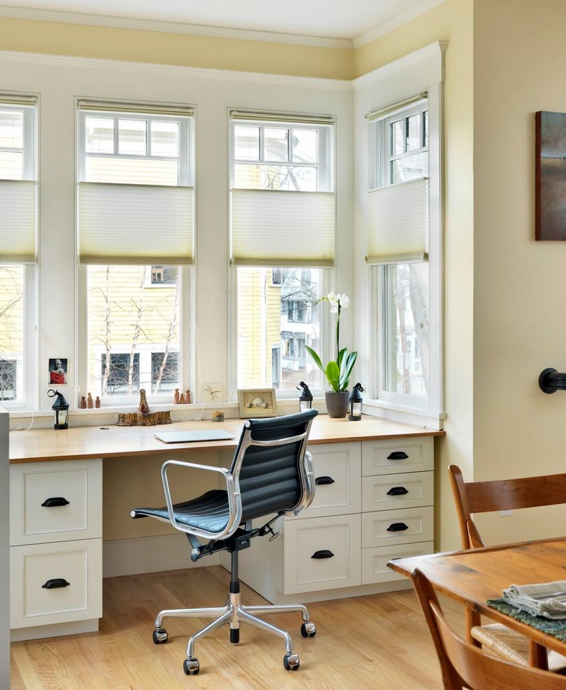 This is an example of a transitional home office in Boston with a built-in desk.