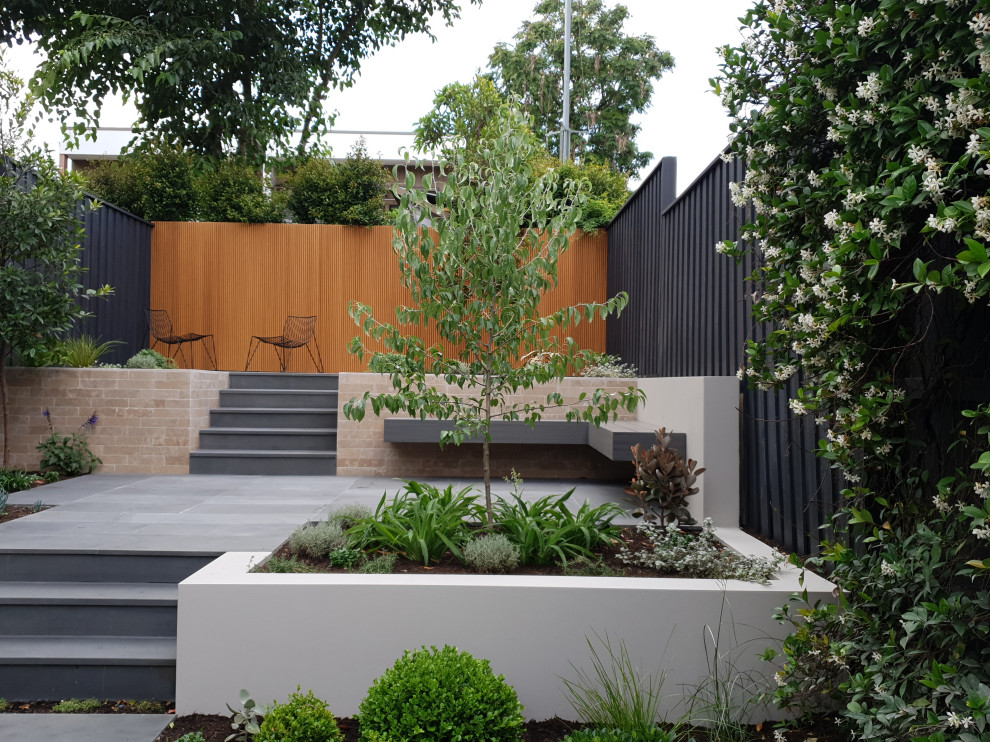 Design ideas for a large contemporary backyard full sun garden in Sydney with natural stone pavers.