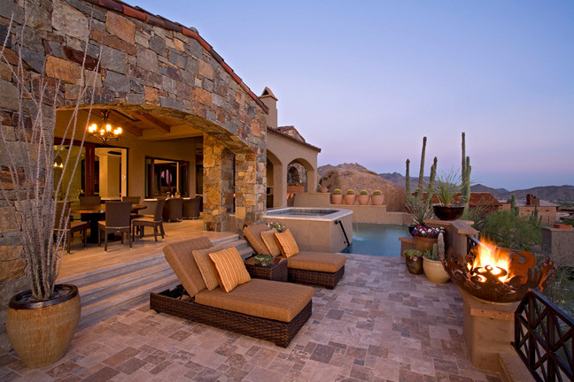 Photo of a contemporary backyard custom-shaped natural pool in Phoenix with natural stone pavers and a hot tub.