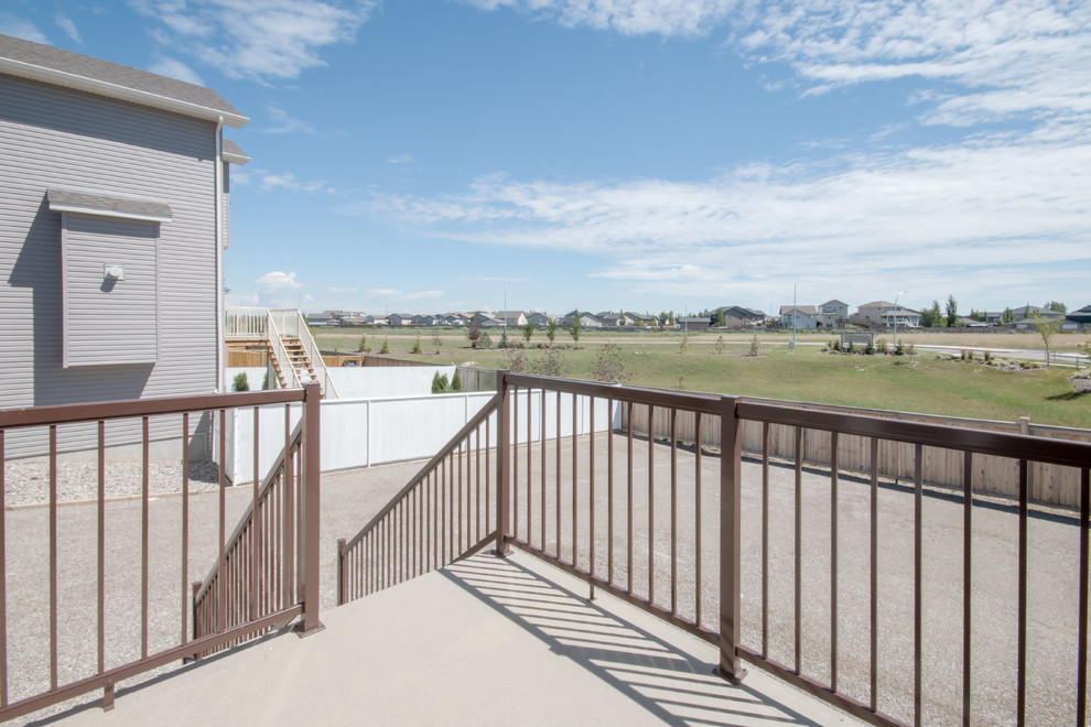 Example of a mid-sized transitional backyard balcony deck design in Calgary with no cover