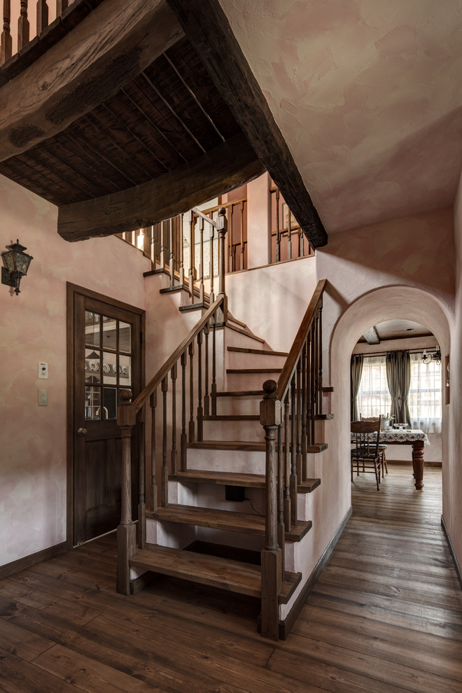 Traditional wood l-shaped staircase in Other with open risers and wood railing.