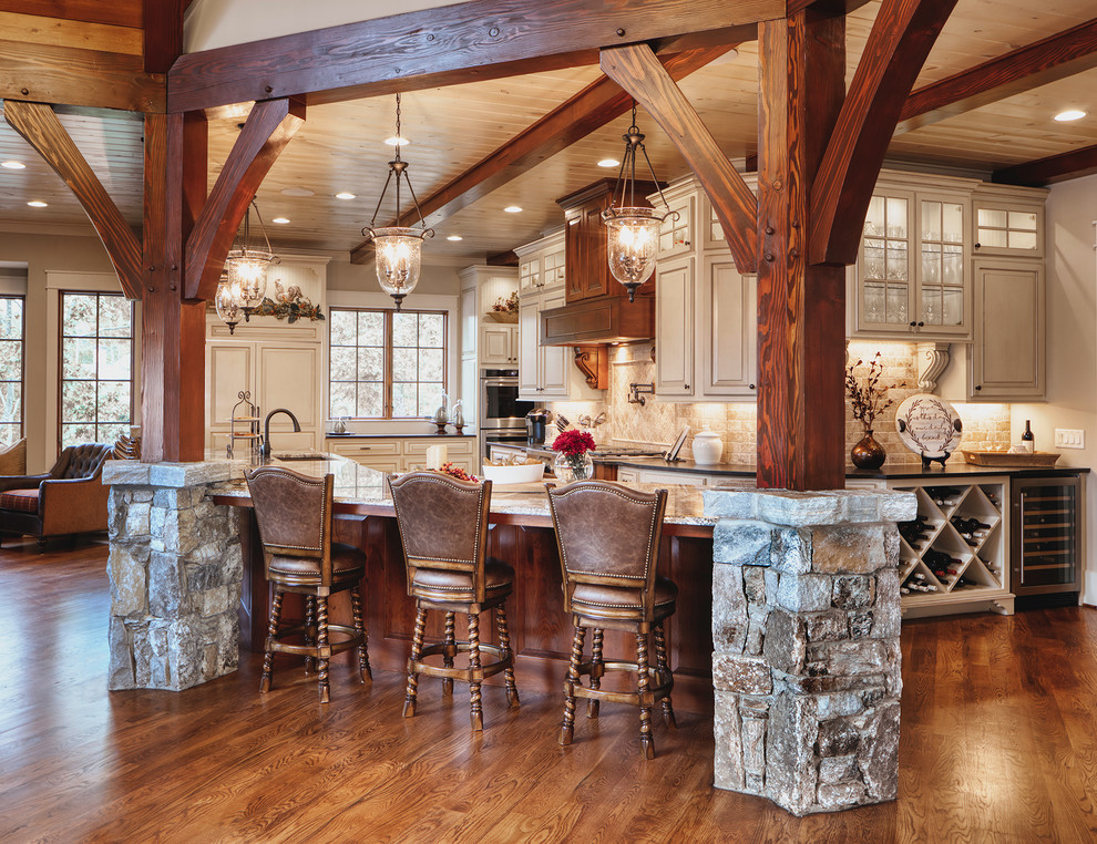 Inspiration for a rustic l-shaped medium tone wood floor and brown floor eat-in kitchen remodel with an undermount sink, raised-panel cabinets, gray cabinets, beige backsplash, paneled appliances, an island and gray countertops