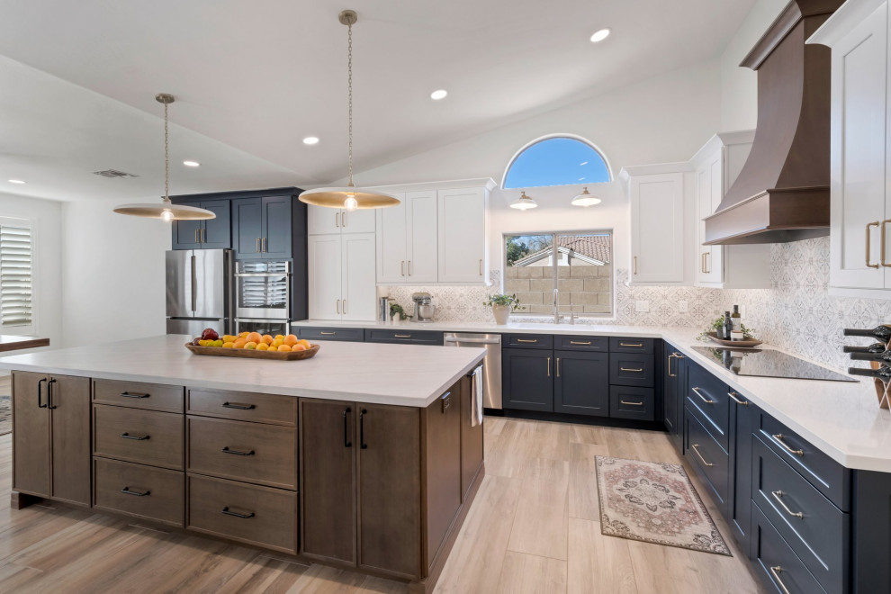 Inspiration for a large transitional l-shaped porcelain tile, brown floor and vaulted ceiling eat-in kitchen remodel in Phoenix with an undermount sink, shaker cabinets, blue cabinets, quartzite countertops, multicolored backsplash, mosaic tile backsplash, stainless steel appliances, two islands and white countertops