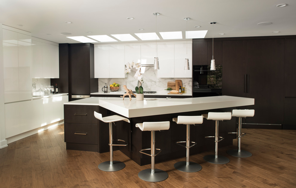 Photo of a contemporary galley kitchen in Calgary with flat-panel cabinets, dark wood cabinets, white splashback, black appliances, dark hardwood floors, with island and brown floor.