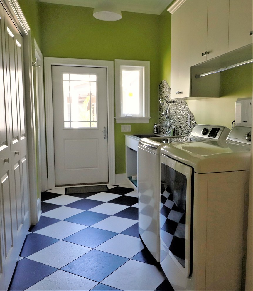 This is an example of a large contemporary single-wall utility room in Wilmington with an utility sink, flat-panel cabinets, white cabinets, limestone benchtops, green walls, vinyl floors, a side-by-side washer and dryer, multi-coloured floor and multi-coloured benchtop.
