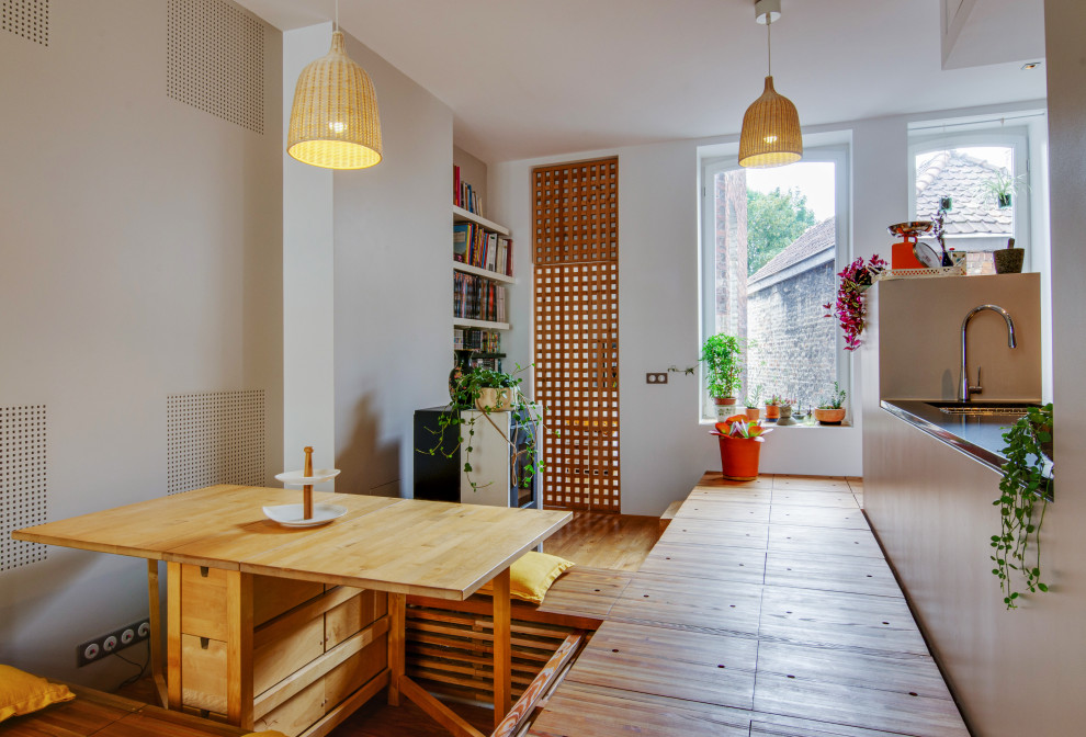 Foto di una piccola sala da pranzo con pareti beige, pavimento in legno massello medio e stufa a legna