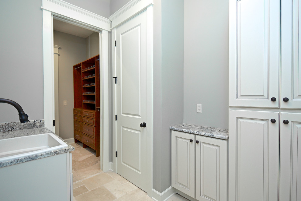 This is an example of a mid-sized beach style bathroom in Jacksonville with raised-panel cabinets, white cabinets, slate, grey walls, travertine floors, a drop-in sink, granite benchtops, beige floor and grey benchtops.