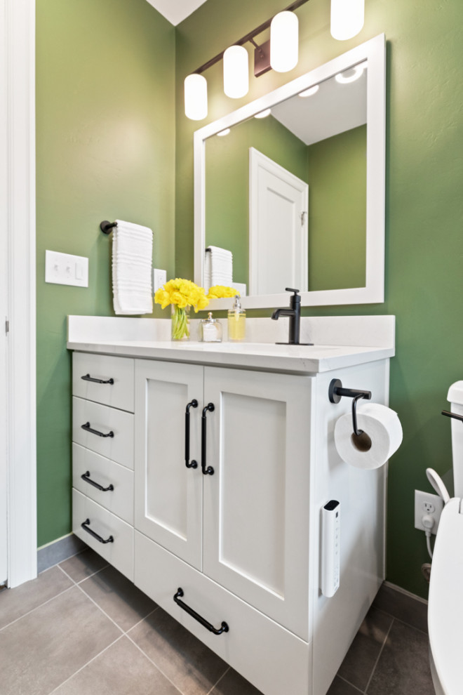 Cette photo montre une petite salle de bain avec des portes de placard blanches, une baignoire d'angle, un combiné douche/baignoire, un bidet, un carrelage blanc, des carreaux de céramique, un mur vert, un sol en carrelage de porcelaine, un lavabo encastré, un sol gris, une cabine de douche avec un rideau, un plan de toilette blanc, meuble simple vasque et meuble-lavabo encastré.