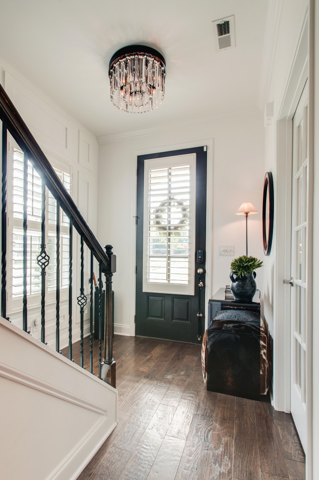 Small midcentury foyer in Nashville with white walls, a single front door, brown floor and decorative wall panelling.