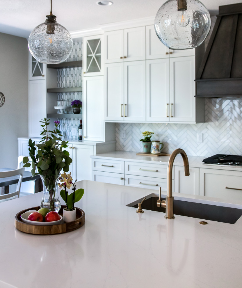 Inspiration for a large transitional galley medium tone wood floor and brown floor open concept kitchen remodel in Denver with an undermount sink, shaker cabinets, white cabinets, quartz countertops, beige backsplash, marble backsplash, stainless steel appliances, an island and white countertops