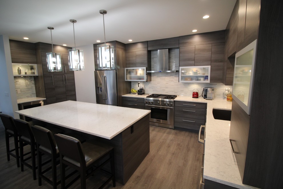 Design ideas for a large modern u-shaped open plan kitchen in Vancouver with an undermount sink, flat-panel cabinets, dark wood cabinets, quartzite benchtops, white splashback, matchstick tile splashback, stainless steel appliances, medium hardwood floors, with island and brown floor.