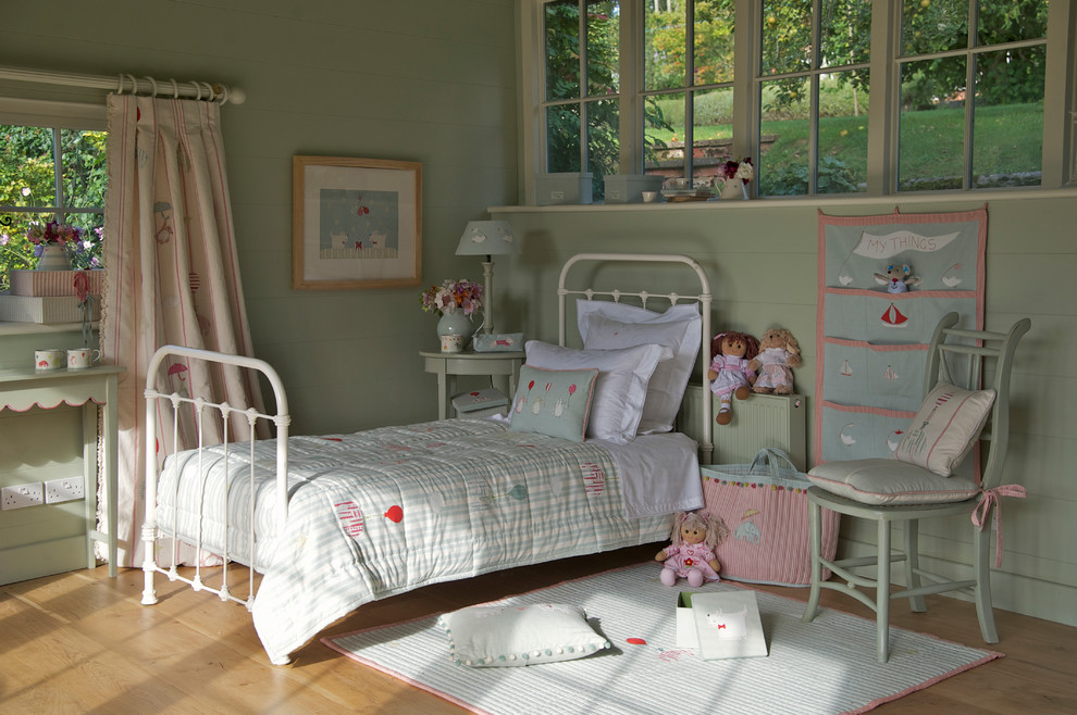 Design ideas for a small country gender-neutral kids' bedroom in Wiltshire with blue walls and medium hardwood floors.