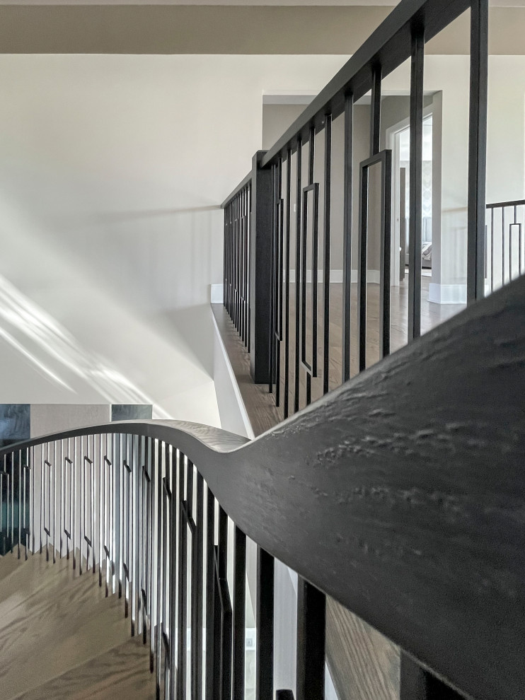 Exemple d'un très grand escalier peint courbe chic avec des marches en bois, un garde-corps en matériaux mixtes et du papier peint.