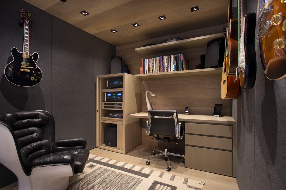 This is an example of a contemporary home office in Denver with light hardwood floors and grey walls.
