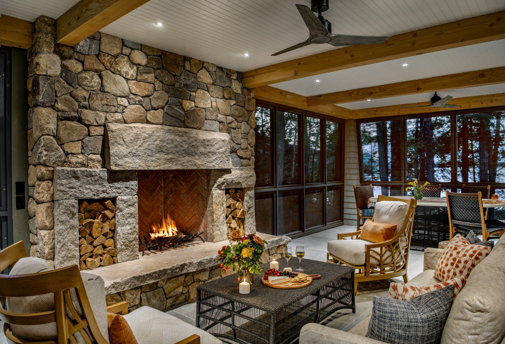 This is an example of a transitional tile porch design with a roof extension and a fireplace.