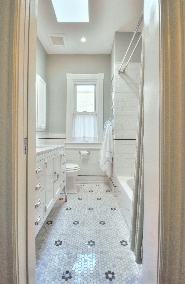 This is an example of a mid-sized traditional master bathroom in DC Metro with an undermount sink, flat-panel cabinets, white cabinets, marble benchtops, an alcove tub, a two-piece toilet, black and white tile, ceramic tile, green walls and marble floors.