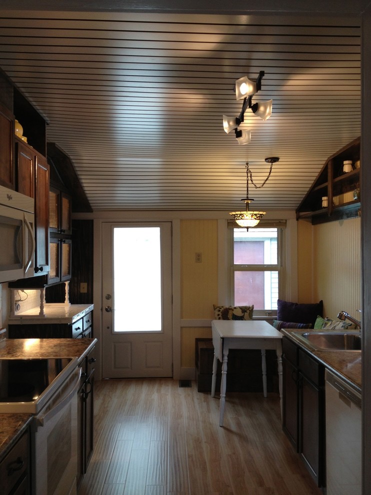 Photo of a small arts and crafts galley eat-in kitchen in Cincinnati with a single-bowl sink, louvered cabinets, dark wood cabinets, laminate benchtops, multi-coloured splashback, ceramic splashback, white appliances and light hardwood floors.