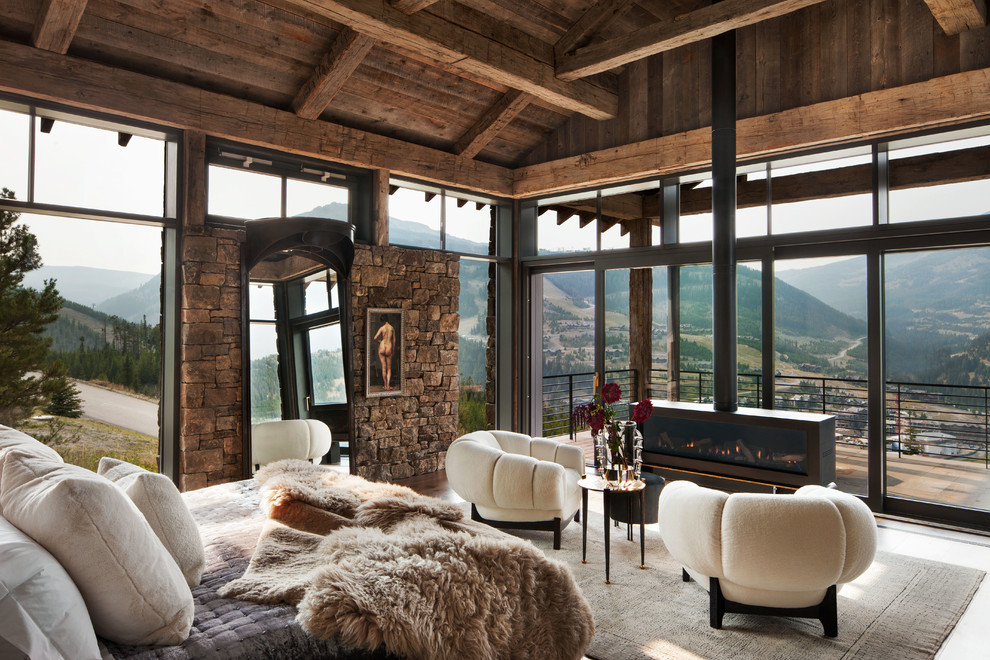 Large mountain style master bedroom photo with a ribbon fireplace