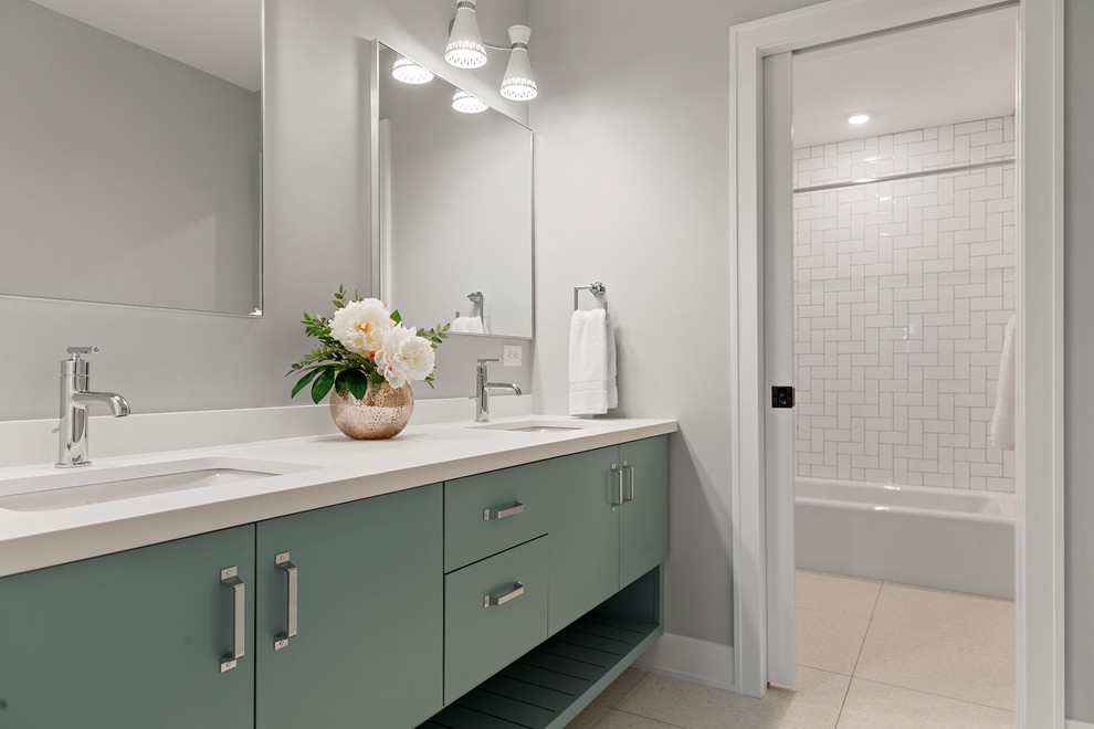 This is an example of a large contemporary kids bathroom in Minneapolis with flat-panel cabinets, turquoise cabinets, an alcove tub, a shower/bathtub combo, white tile, ceramic tile, grey walls, ceramic floors, an undermount sink, engineered quartz benchtops, beige floor, a shower curtain and white benchtops.
