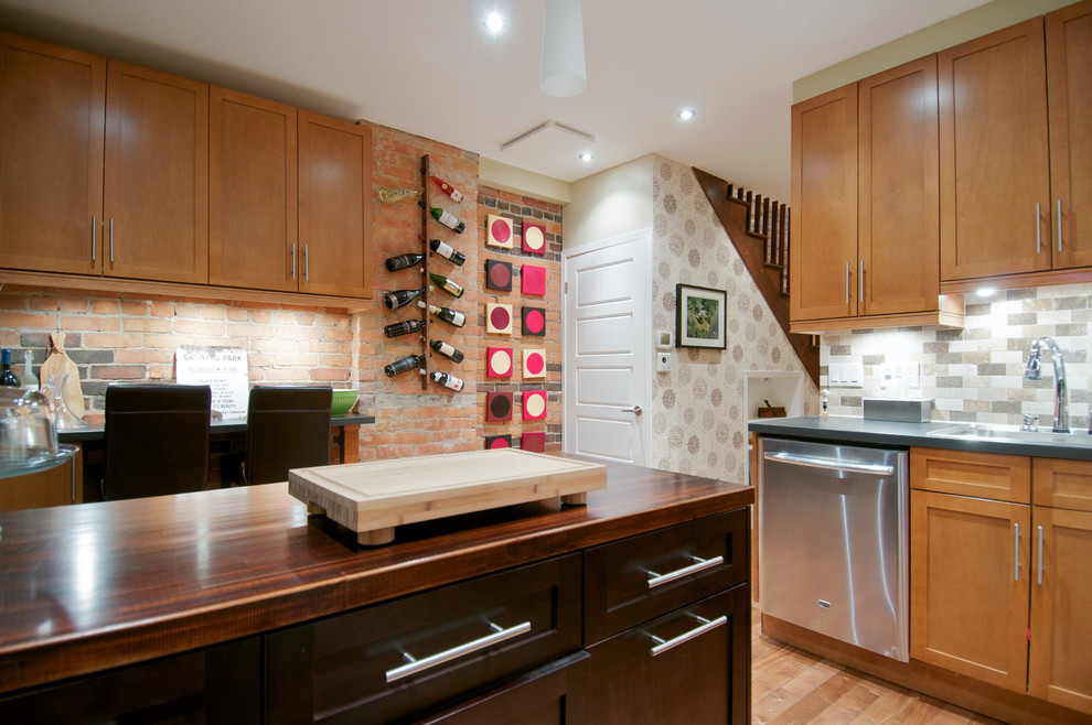 Enclosed kitchen - mid-sized transitional u-shaped medium tone wood floor and multicolored floor enclosed kitchen idea in Toronto with a double-bowl sink, shaker cabinets, medium tone wood cabinets, wood countertops, multicolored backsplash, porcelain backsplash, stainless steel appliances and an island