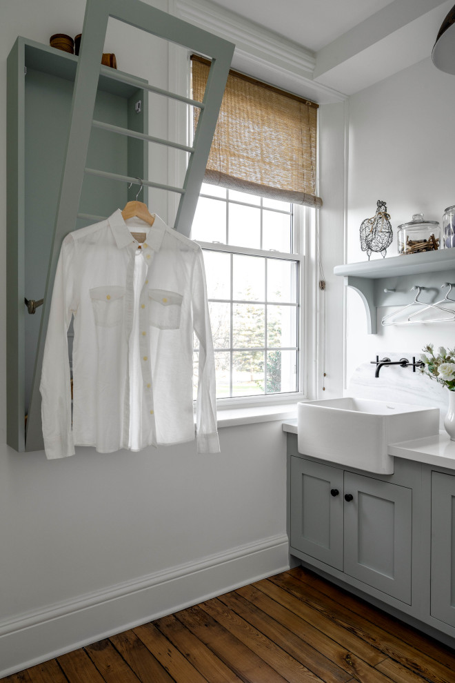 Inspiration för en liten vita linjär vitt tvättstuga enbart för tvätt, med en rustik diskho, luckor med infälld panel, blå skåp, marmorbänkskiva, vitt stänkskydd, stänkskydd i marmor, vita väggar, ljust trägolv, en tvättpelare och brunt golv