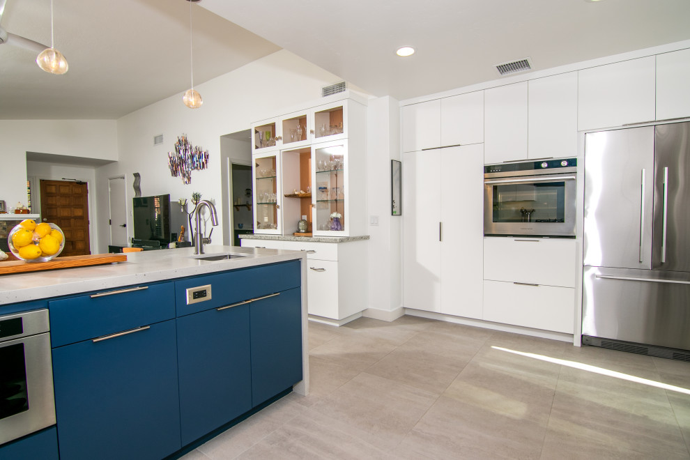 Photo of a large modern u-shaped kitchen/diner in San Diego with a submerged sink, flat-panel cabinets, white cabinets, engineered stone countertops, white splashback, ceramic splashback, stainless steel appliances, porcelain flooring, beige floors and white worktops.