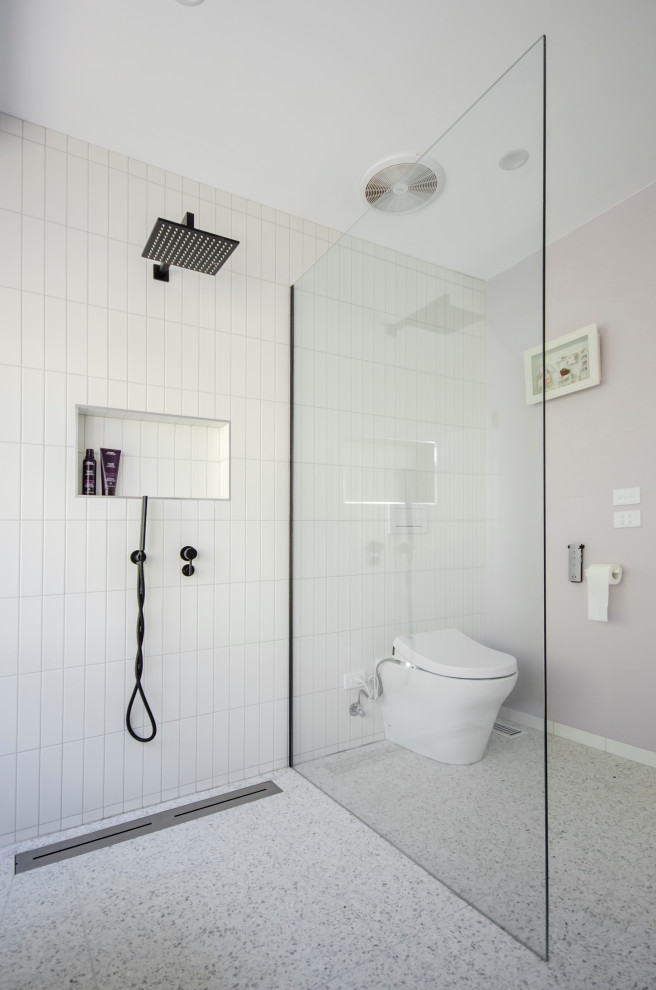 Modern inredning av ett stort vit vitt badrum, med luckor med profilerade fronter, vita skåp, ett fristående badkar, en öppen dusch, en bidé, rosa kakel, cementkakel, rosa väggar, terrazzogolv, ett nedsänkt handfat, bänkskiva i terrazo, vitt golv och med dusch som är öppen