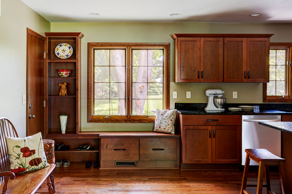 Eat-in kitchen - large transitional l-shaped medium tone wood floor eat-in kitchen idea in Milwaukee with an undermount sink, shaker cabinets, medium tone wood cabinets, granite countertops, green backsplash, stone slab backsplash, stainless steel appliances and an island