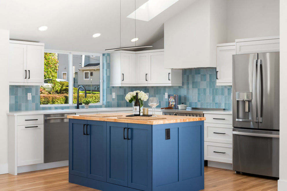 Exempel på ett mellanstort 60 tals vit vitt kök, med en undermonterad diskho, skåp i shakerstil, blå skåp, träbänkskiva, blått stänkskydd, stänkskydd i keramik, rostfria vitvaror, mellanmörkt trägolv, en köksö och brunt golv