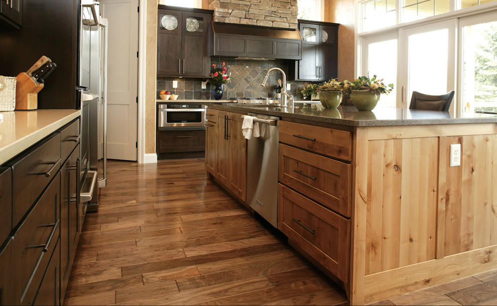 Large transitional l-shaped dark wood floor kitchen photo with an undermount sink, recessed-panel cabinets, dark wood cabinets, stainless steel appliances and an island