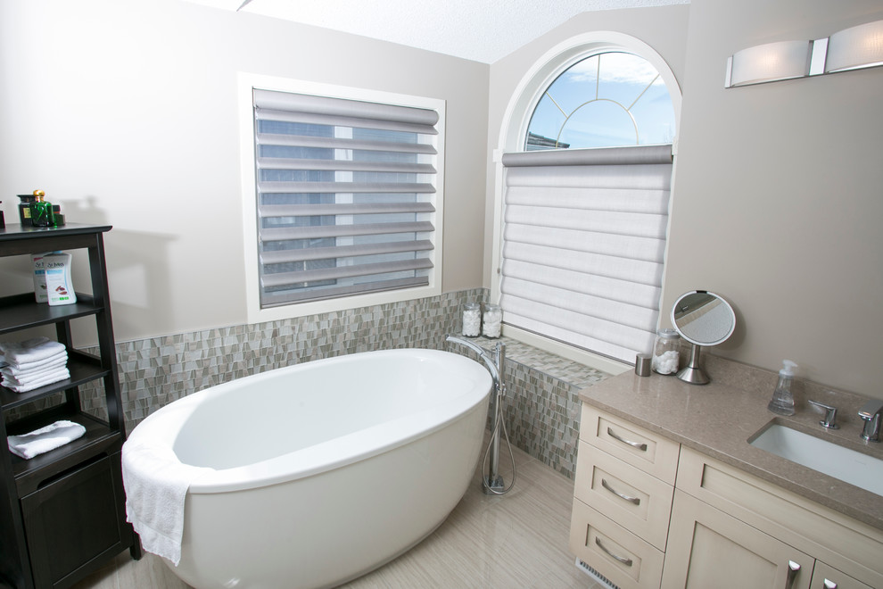 This is an example of a mid-sized modern bathroom in Edmonton with a drop-in sink, dark wood cabinets, a freestanding tub, a double shower, white walls and slate floors.