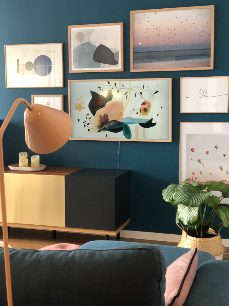 Inspiration for a small scandinavian open plan living room in Lyon with blue walls, light hardwood flooring, no fireplace, a wall mounted tv and brown floors.