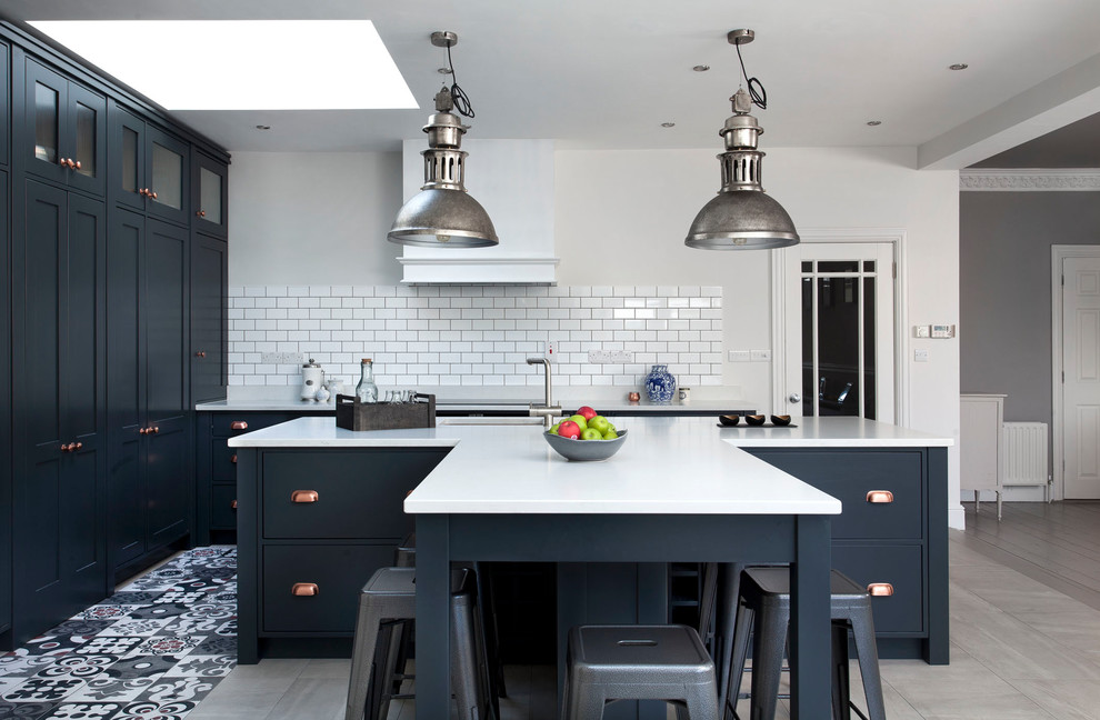 Mid-sized transitional l-shaped kitchen in Other with shaker cabinets, blue cabinets, quartzite benchtops, white splashback, ceramic splashback, ceramic floors, with island, an undermount sink and grey floor.