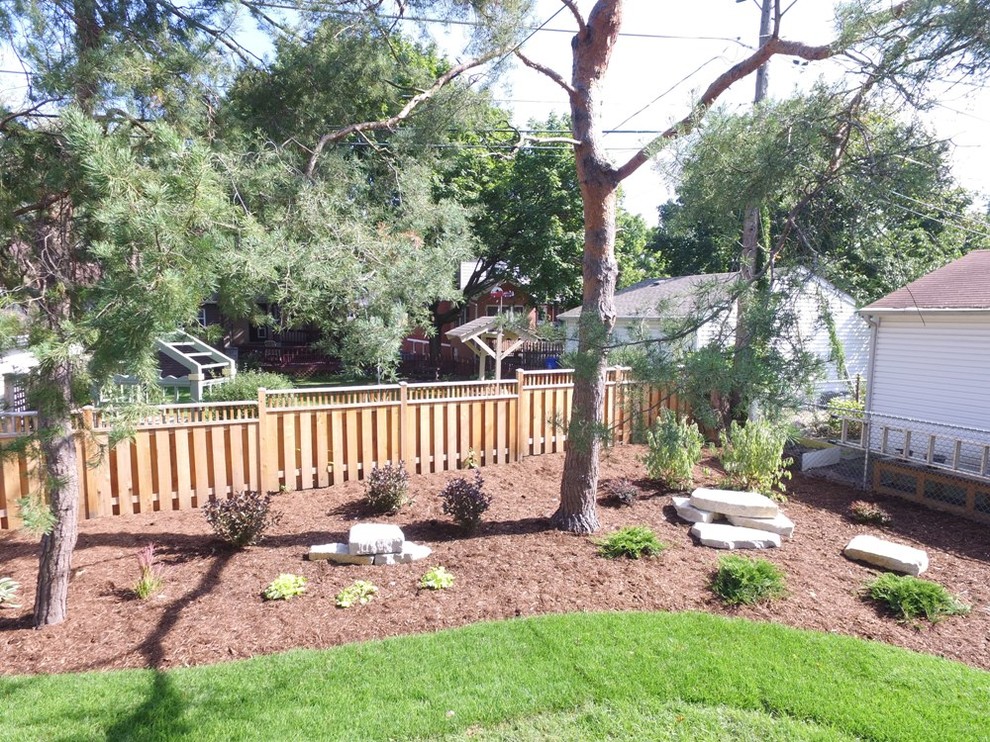This is an example of a large traditional backyard full sun formal garden in Chicago with mulch.
