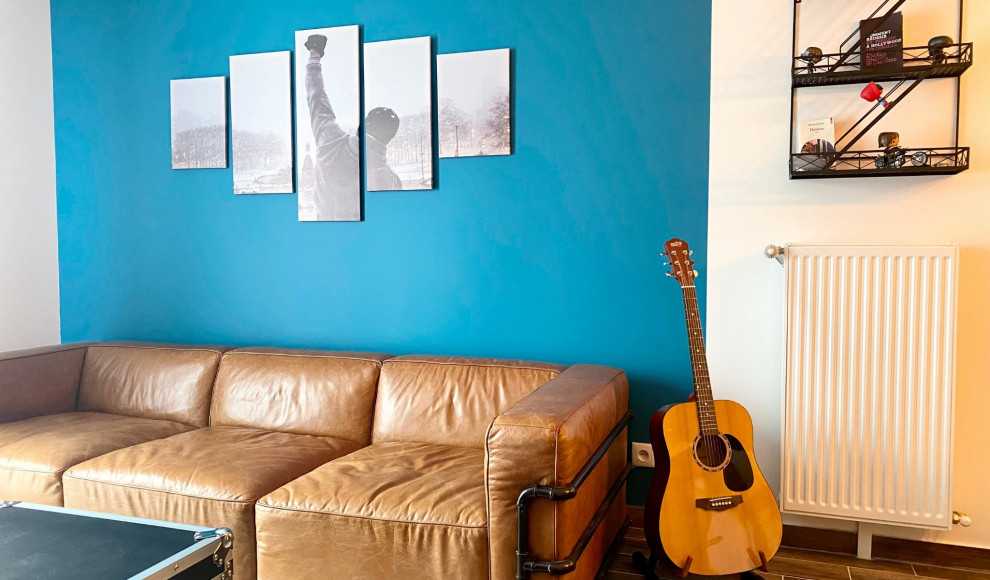 パリにあるお手頃価格の中くらいなインダストリアルスタイルのおしゃれなリビング (青い壁、濃色無垢フローリング、暖炉なし、壁掛け型テレビ、茶色い床) の写真